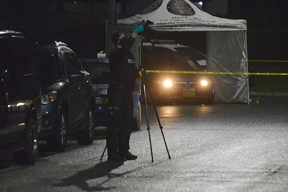 An investigator sets up a camera near a vehicle under investigation by IHIT at a murder scene in Langley City Wednesday morning. (Matthew Claxton/Langley Advance Times)
