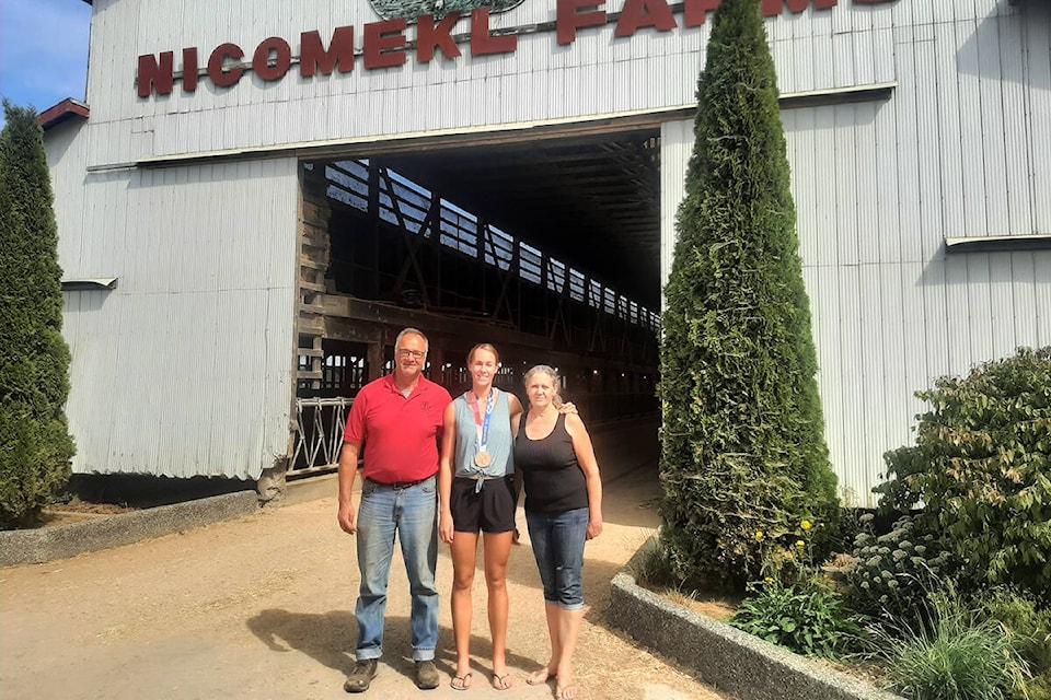 Olympic bronze medalist Hillary Janssens is flanked by her father David and mother Sandy on the family dairy farm in Cloverdale. (Photo: submitted)