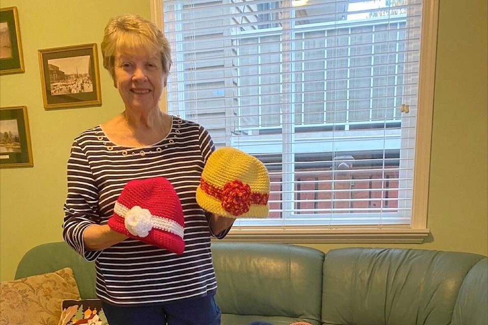 June Young shows a couple of the toques she has crocheted for donation this year. (Contributed photo)
