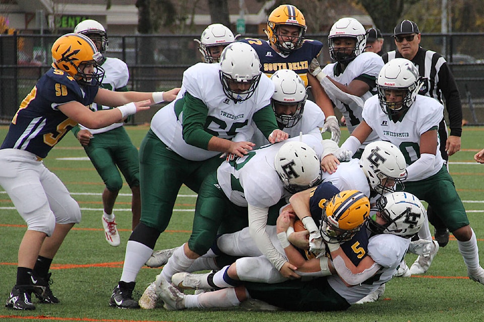 The Lord Tweedsmuir defense swarm-tackles South Delta running back Jesse Mitran Nov. 12. Tweedsmuir won the wildcard playoff games 35-14. (Photo: Malin Jordan)