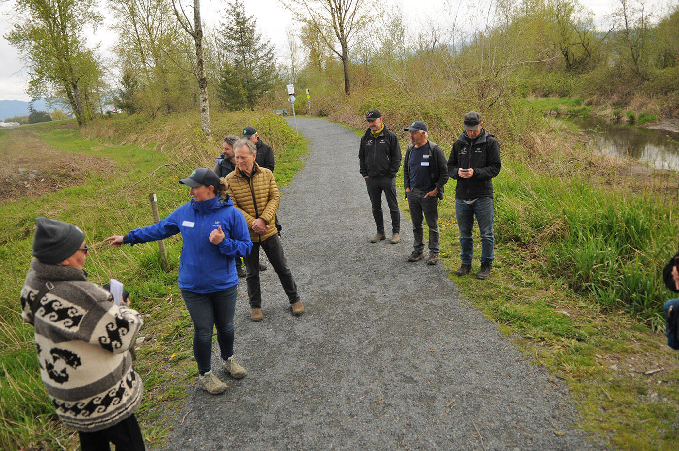 Natasha Cox with Fraser Valley Watersheds Coalition (blue coat) takes folks on a tour of Hooge Wetlands in Chilliwack on Thursday, April 21, 2022. To the left is a channel that was built in 2017 that connects with Peach Creek (at right) and runs through the wetlands. (Jenna Hauck/ Chilliwack Progress)