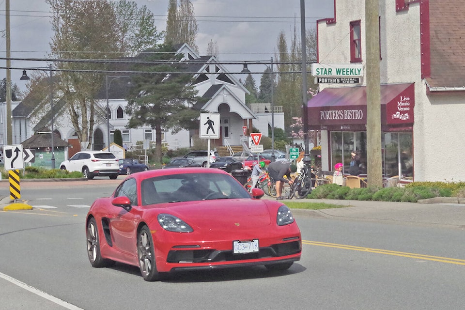 One of 40 Porsches following a historic route passed by the historic Porters Bistro building at the intersection of Old Yale Road and 216th Street in Langley on Sunday, May 1. (Graham MacDonell/Special to Langley Advance Times)