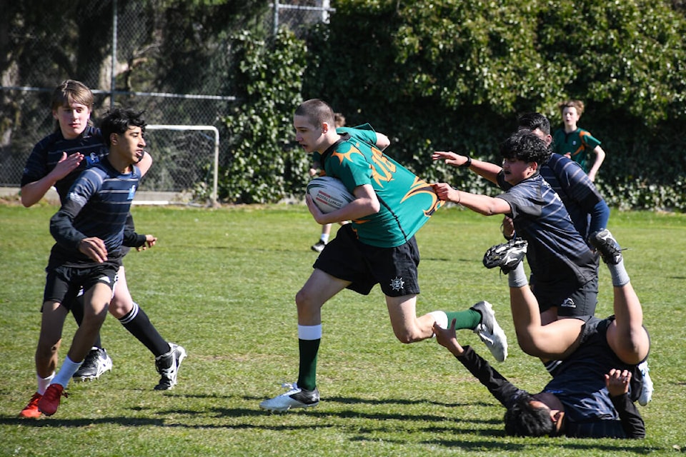 Earl Marriott Grade 8 rugby player Connor Marsh (with ball) battles to break free of an L.A. Matheson player Tuesday (April 4). (Photo: EMS Photography)