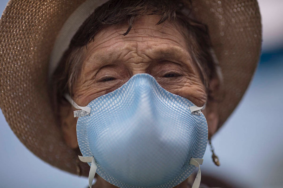 Ubaldina Calderon, 92, wearing a protective mask, exits a clinic after receiving a pneumonia vaccine as part of a mass vaccination campaign for the elderly in Lima, Peru, Friday, March 13, 2020. The Ministry of Health is encouraging seniors to get a pneumonia vaccine to reduce the risks of those who might contact the new coronavirus. (AP Photo/Rodrigo Abd)