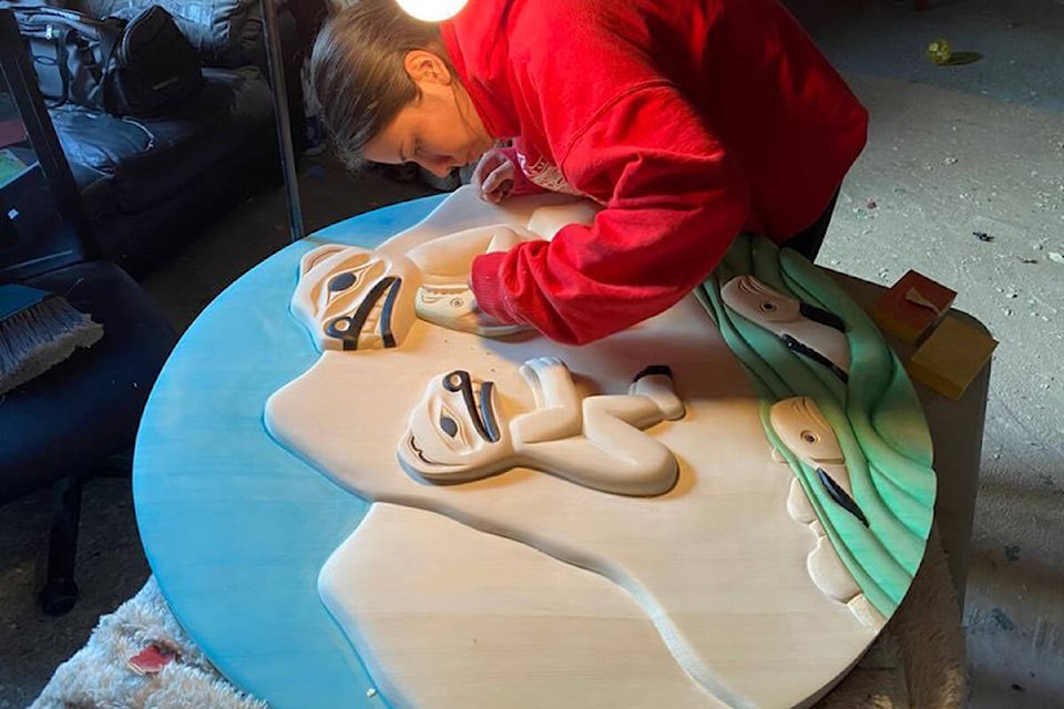 Jade Hanuse works on a panel under the mentorship of master carver Dempsey Bob. (Photo Submitted)