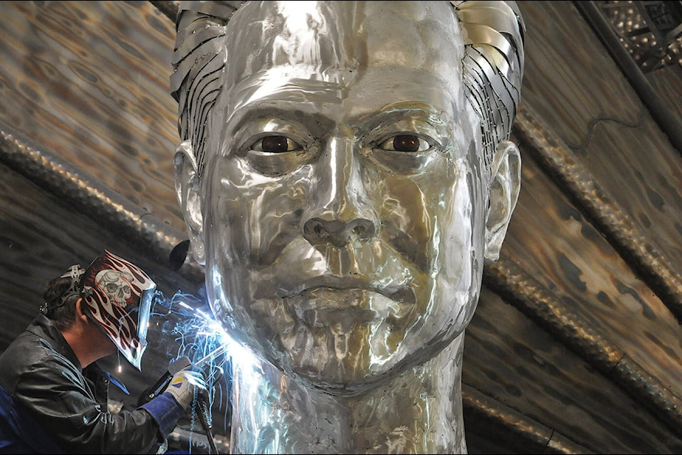 Kevin Stone works on a gigantic Elon Musk head on May 27, 2022. (Jenna Hauck/ Chilliwack Progress)