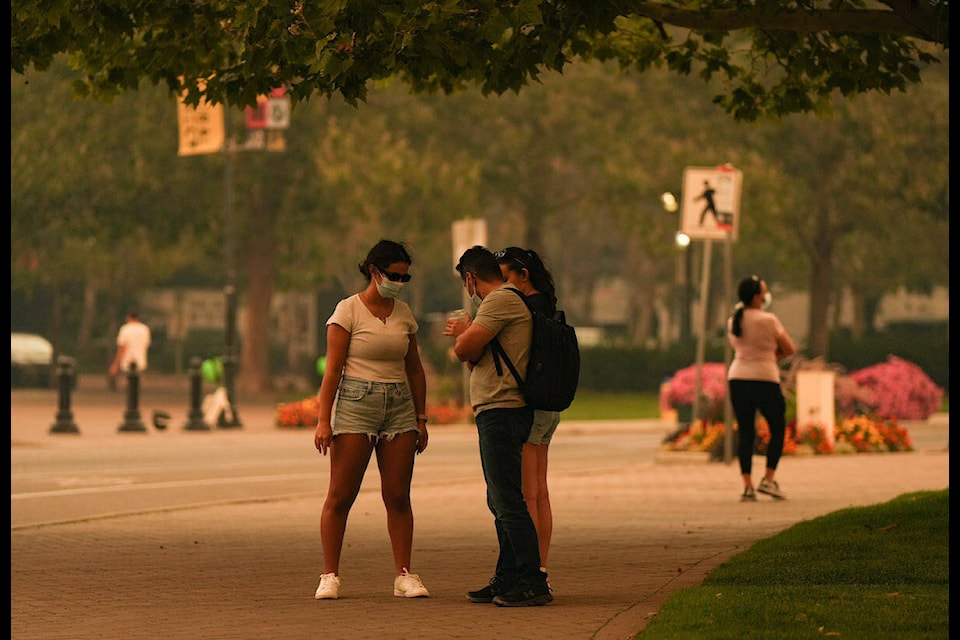 People wear masks due to poor air quality as smoke from the McDougall Creek wildfire fills the air in Kelowna, B.C., Friday, Aug. 18, 2023. THE CANADIAN PRESS/Darryl Dyck