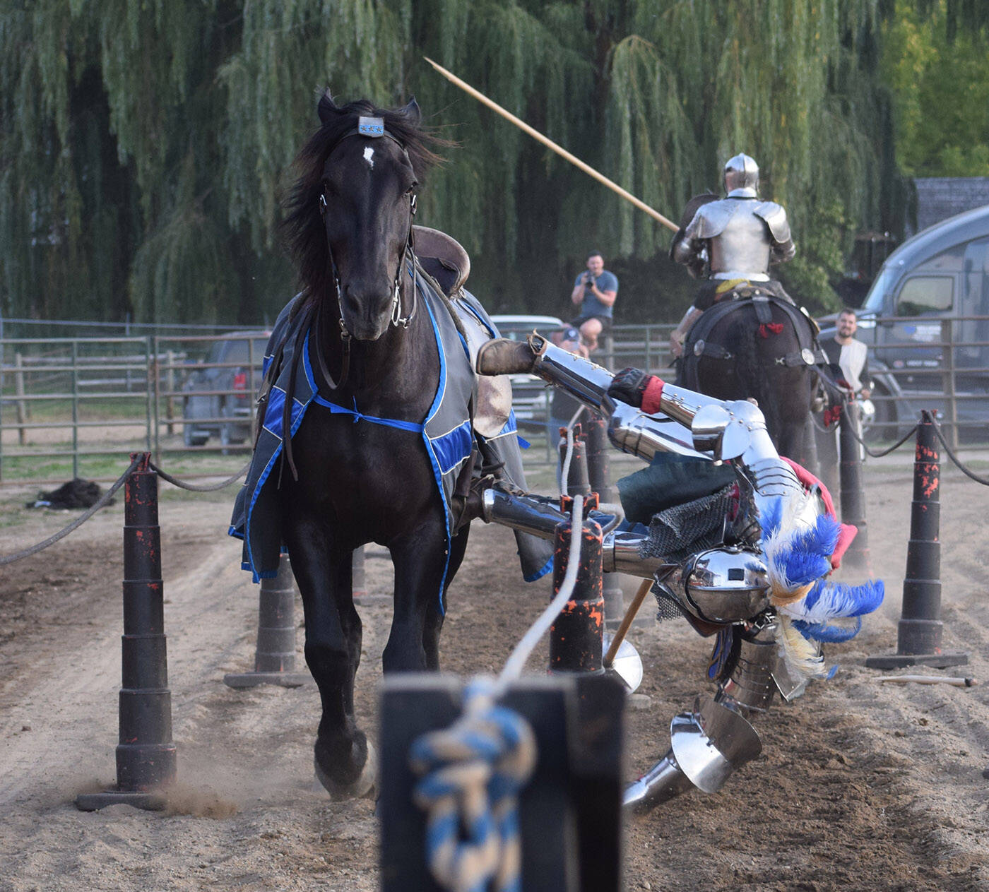 Josh Tobey (left), whos a member of jousting troupe Knights of Valour, falls off his horse during a match at the Salmon Arm Fair in September 2023. (Lindsay Adam)