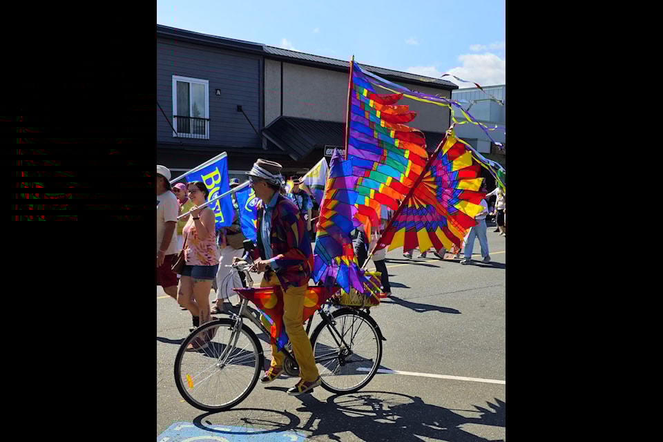 Bike with colourful flags leading the parade. 