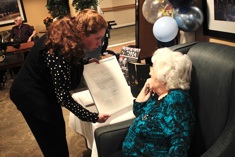 Granddaughter Kelli Andrews shows birthday girl Exilda "Della" Allen the letter Allen received from the Governor General. 