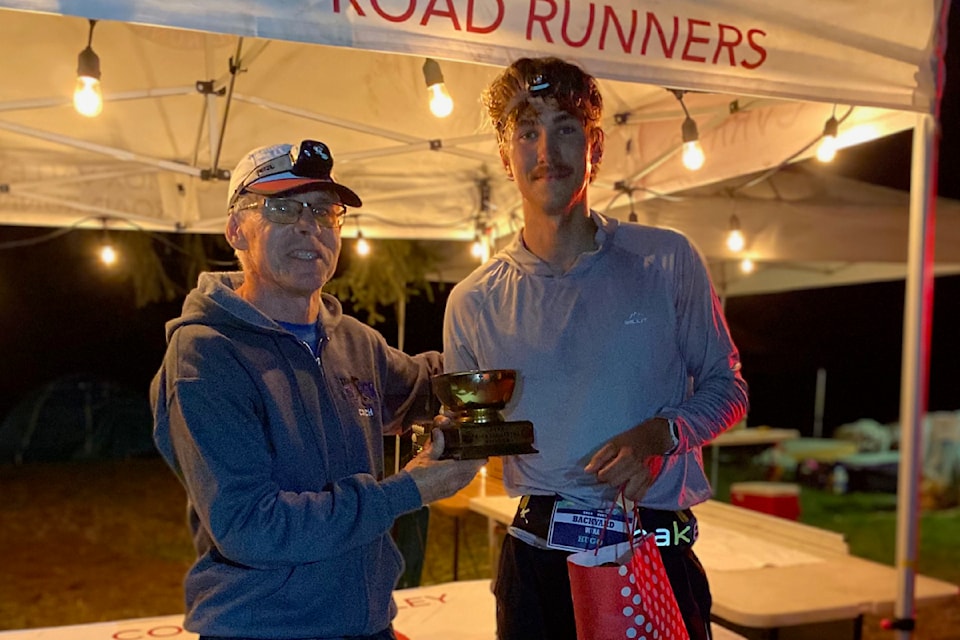 Winner Hugo Henckel poses with his trophy after running 134 km. 