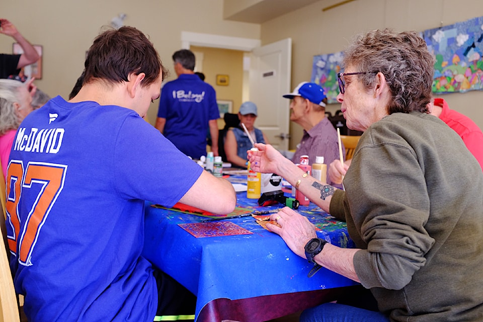 A few people participate in a jelly printing workshop hosted by L'Arche Comox Valley during their open house on June 12, 2024. 