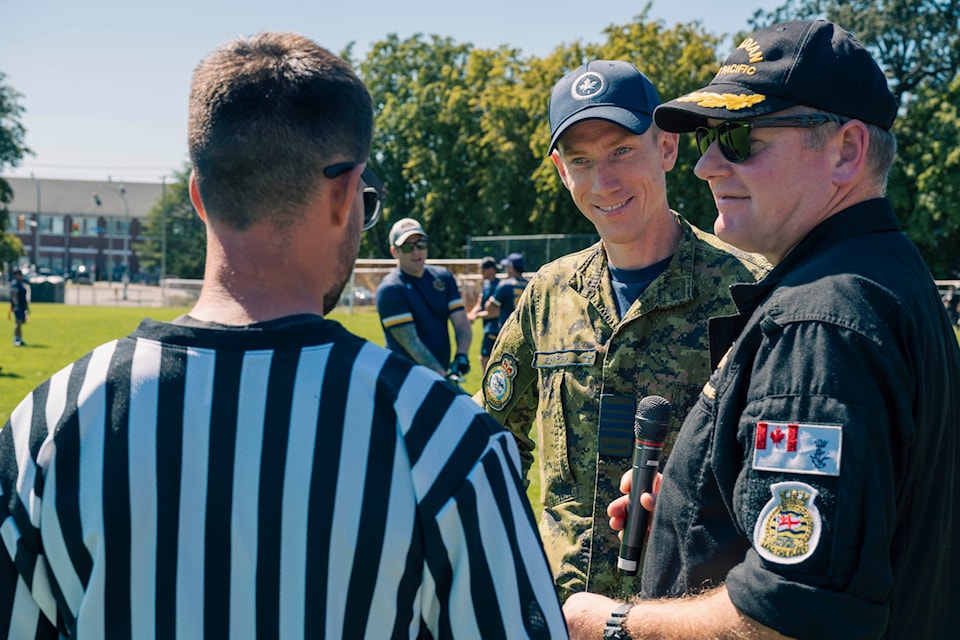Col. Chris Shapka, base commander for Canadian Forces Base Comox and Commodore of Canadian Fleet Pacific David Mazur converse with the referee during a flag football game for the Commodores cup held at Canadian Forces Base Esquimalt on Aug. 29, 2024.
