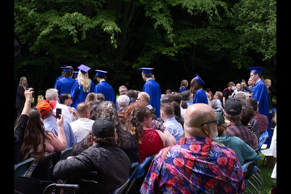 Graduates start walking in through the audience.