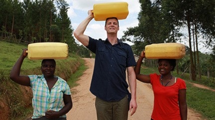 Nate Lepp helps deliver water during his visit to Uganda.