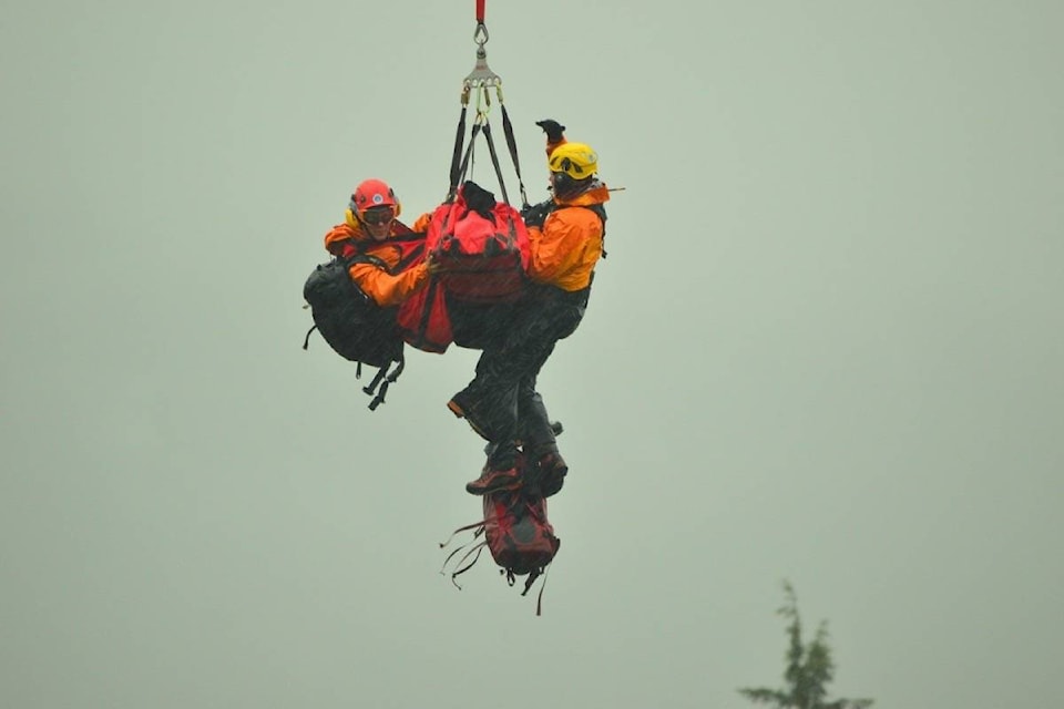 Search and rescue crews descend with Annette Poitras, the Coquitlam dog walker they just rescued from the woods. (Katya Slepian/Black Press)