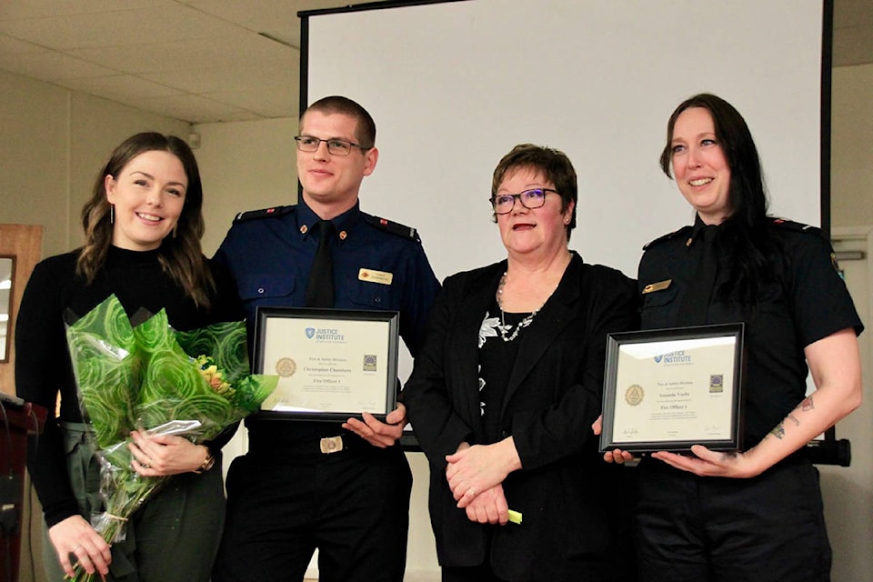 Strathcona Regional District Area D director Brenda Leigh presenting Fire Officer 1 certificates to Chris Chambers and Amanda Voeltz.