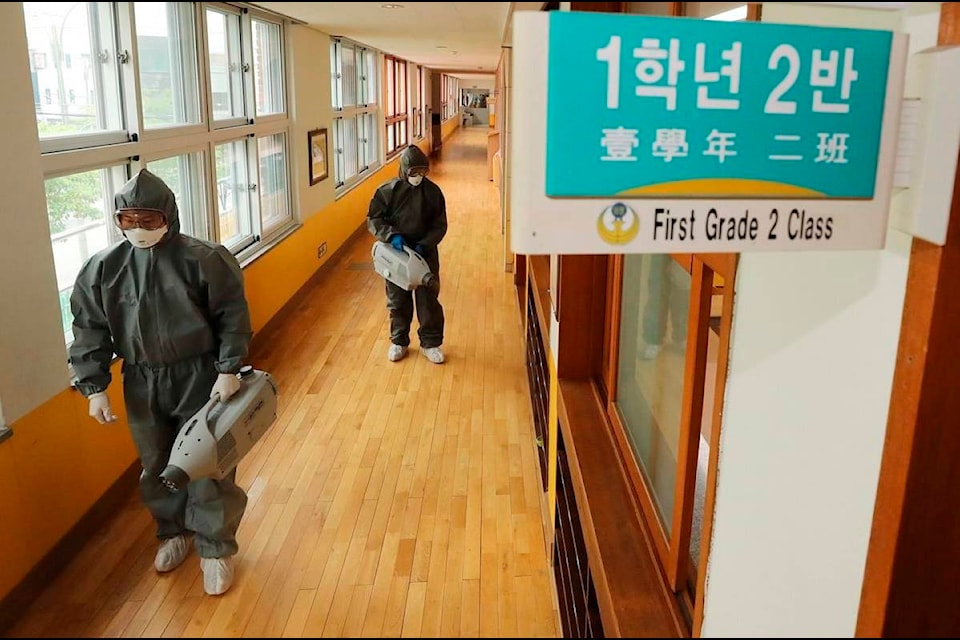 Workers disinfect as a precaution against the new coronavirus ahead of school reopening at an elementary school in Gwangju, South Korea, Tuesday, May 26, 2020. (Park Chul-hong/Yonhap via AP)