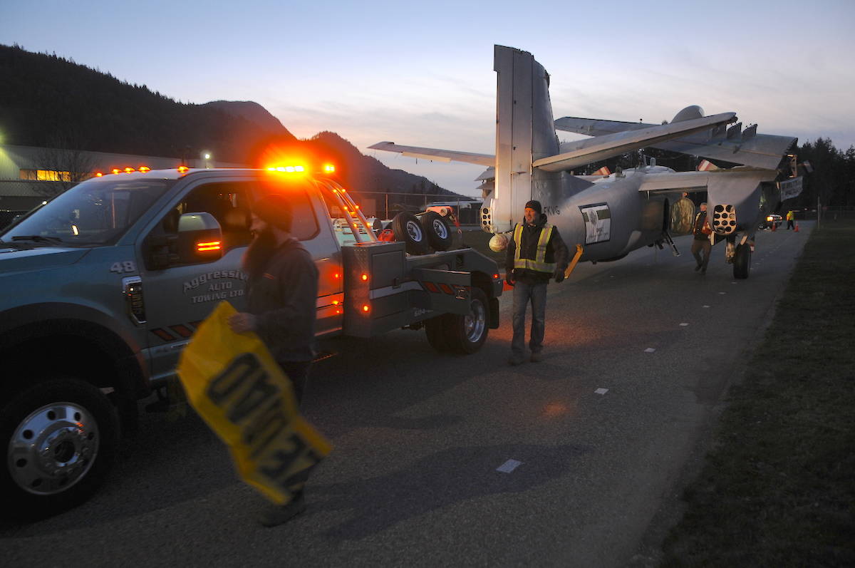Crews with Discovery Channel film as an Aggressive Towing driver moves a Grumman S2F Tracker aircraft around a 90-degree turn from its compound and onto the road on Saturday, Jan. 23, 2021. It was the most difficult part of the move for the airplane, one organizer said. (Jenna Hauck/ Chilliwack Progress)