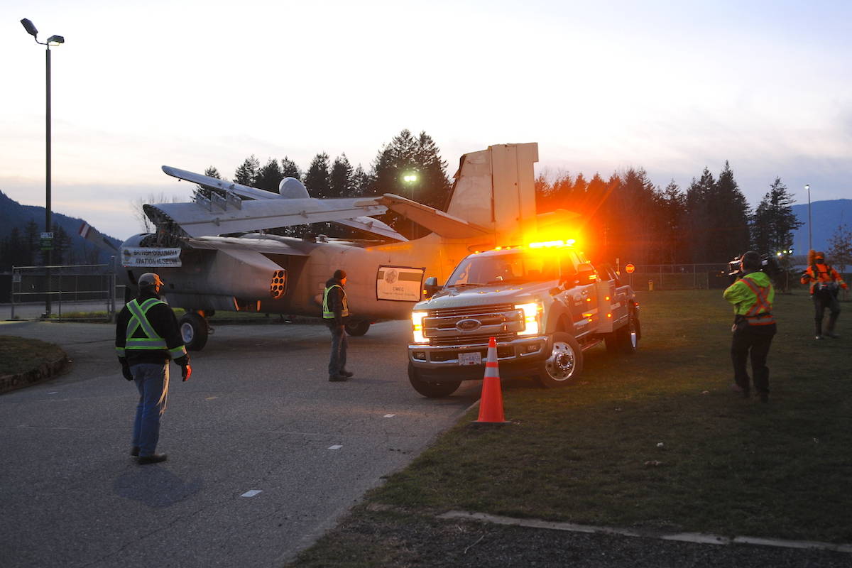 Crews with Discovery Channel film as an Aggressive Towing driver moves a Grumman S2F Tracker aircraft around a 90-degree turn from its compound and onto the road on Saturday, Jan. 23, 2021. It was the most difficult part of the move for the airplane, one organizer said. (Jenna Hauck/ Chilliwack Progress)