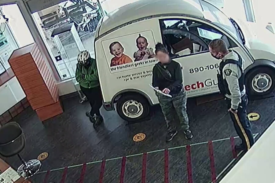 A Comox Valley RCMP office discusses the situation with maskless woman after she forced herself into the My Tech Guys outlet on Cliffe Avenue in Courtenay, defying public health orders. Photo supplied.