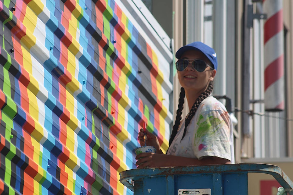 Annika Funk puts the finishing touches on her ‘Be Kind’ mural on 6th Street in Courtenay, above the AIDS Vancouver Island offices. Photo by Terry Farrell