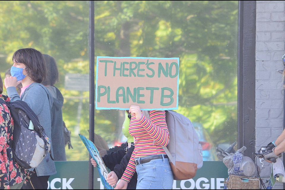 A marcher shows off her message along Cliffe Avenue during a climate strike by students through downtown Courtenay. Photo by Mike Chouinard