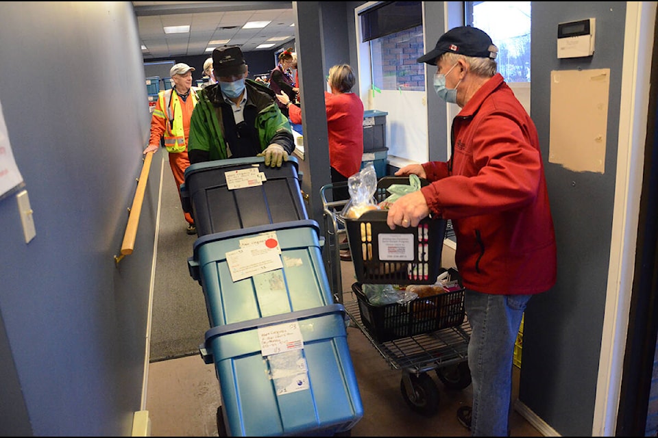 Volunteers get ready to bring the hampers outside for pickup. Photo by Mike Chouinard