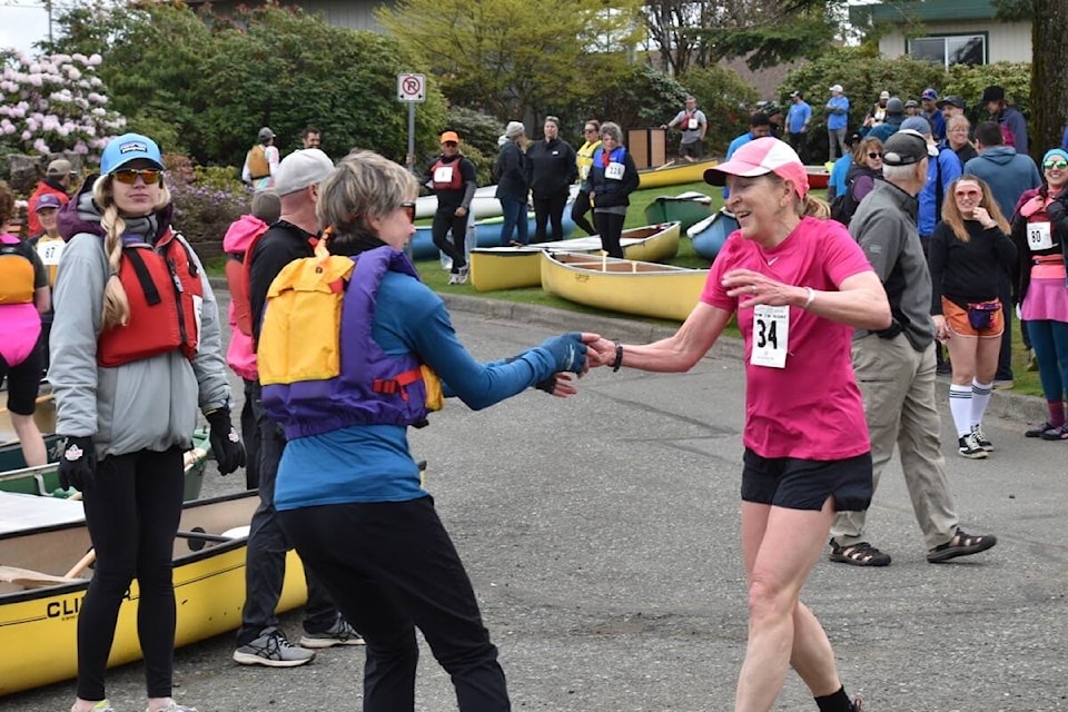 A runner tags a canoeist at the Courtenay Marina launch — the final leg of the 2022 Royal LePage Snow to Surf, Sunday. Scott Stanfield photos