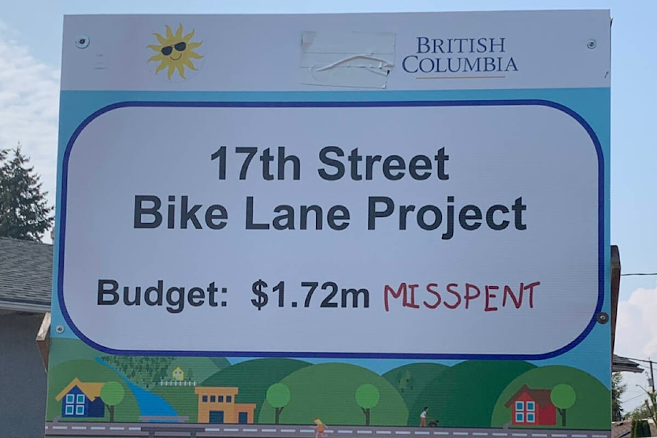 This sign, at the beginning of the 17 Street (bike lane) Project, originally had the City of Courtenay logo on the top left-hand side (where the sun sticker is). The city’s chief election officer contacted Brennan Day to have the logo removed. Photo by Terry Farrell