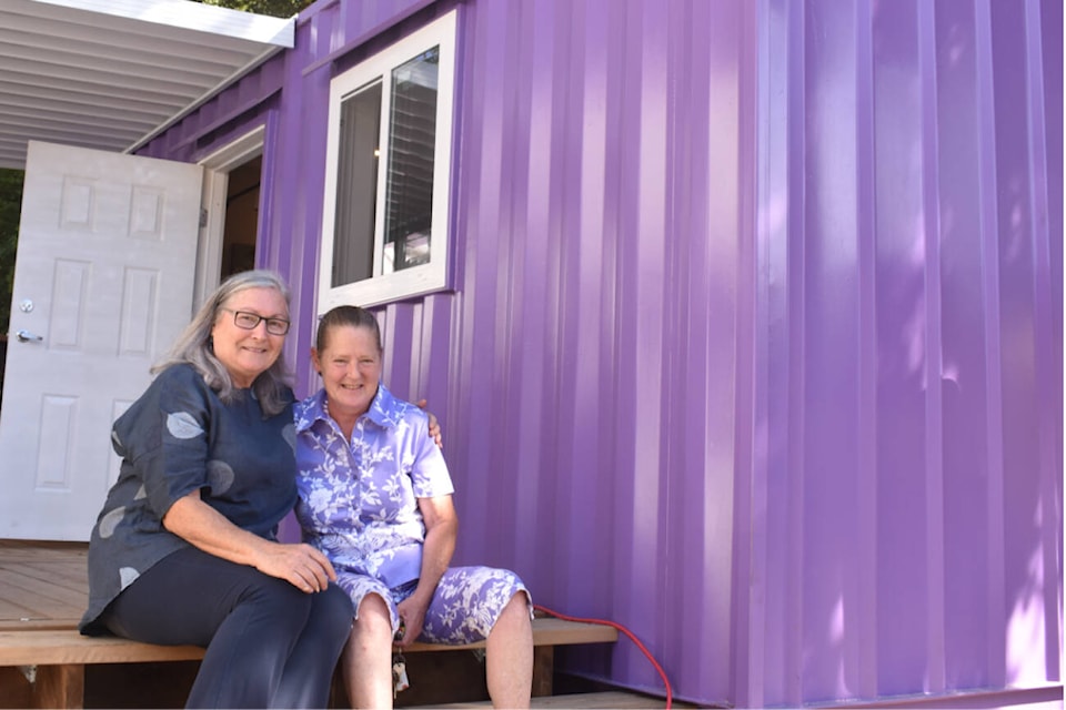 WeCan Shelter Society co-founder Charlene Davis and their latest recipient, Kim Hamilton, sit outside Kim’s new home. Photo by Terry Farrell