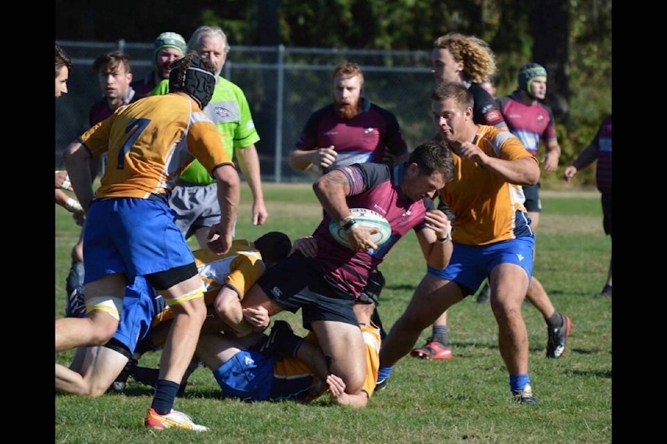 8-man Joe Barker getting tackled by two defenders. Photo by Natalie Nguyen