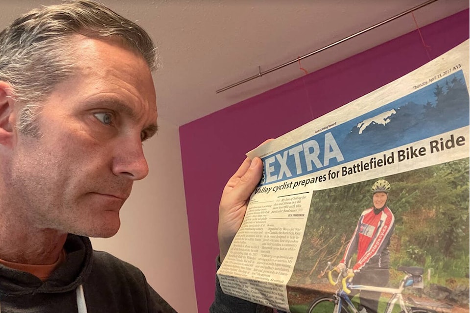 Alex Kennedy looks over a 2017 article about his wife’s cycling efforts. Photo supplied