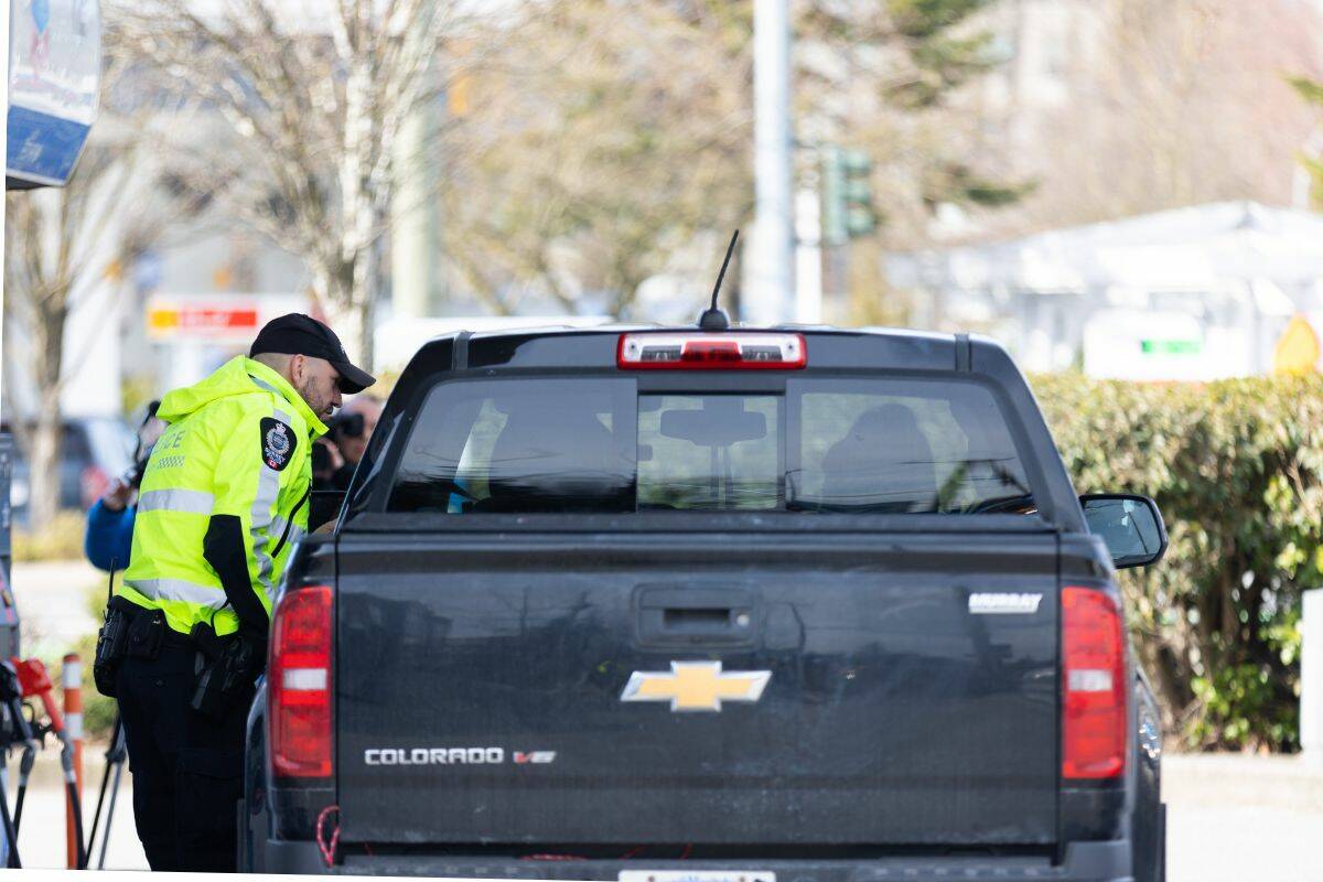 A Surrey Police officer talking to a driver he pulled over during Operation Hang Up at 152 Street and Highway 10 on March 9, 2023. (Photo: Anna Burns)