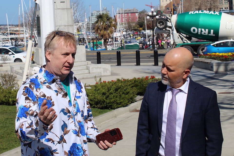 Disability advocate Jeff Leggat (left) and Saanich North and the Islands MLA Adam Olsen of the BC Greens (right) discuss the importance of disability funding outside the B.C. legislature Thursday (March 30). (Brendan Mayer/News Staff)