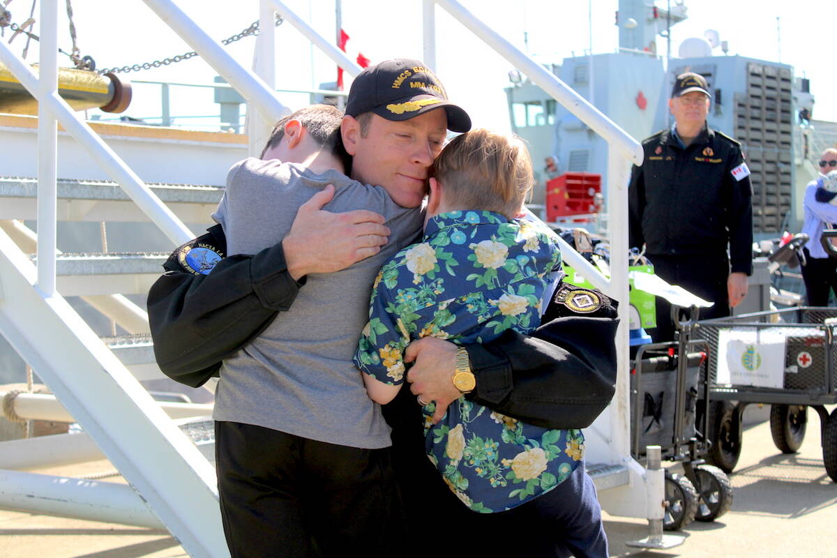 HMCS Edmonton commanding officer Tyler Smith hugs his two sons as he and other members of the ship returned home on April 28. The vessel was on a two-and-a-half month deployment involved in a multi-nation narcotics-combatting operation off of Central America. (Jake Romphf/News Staff)