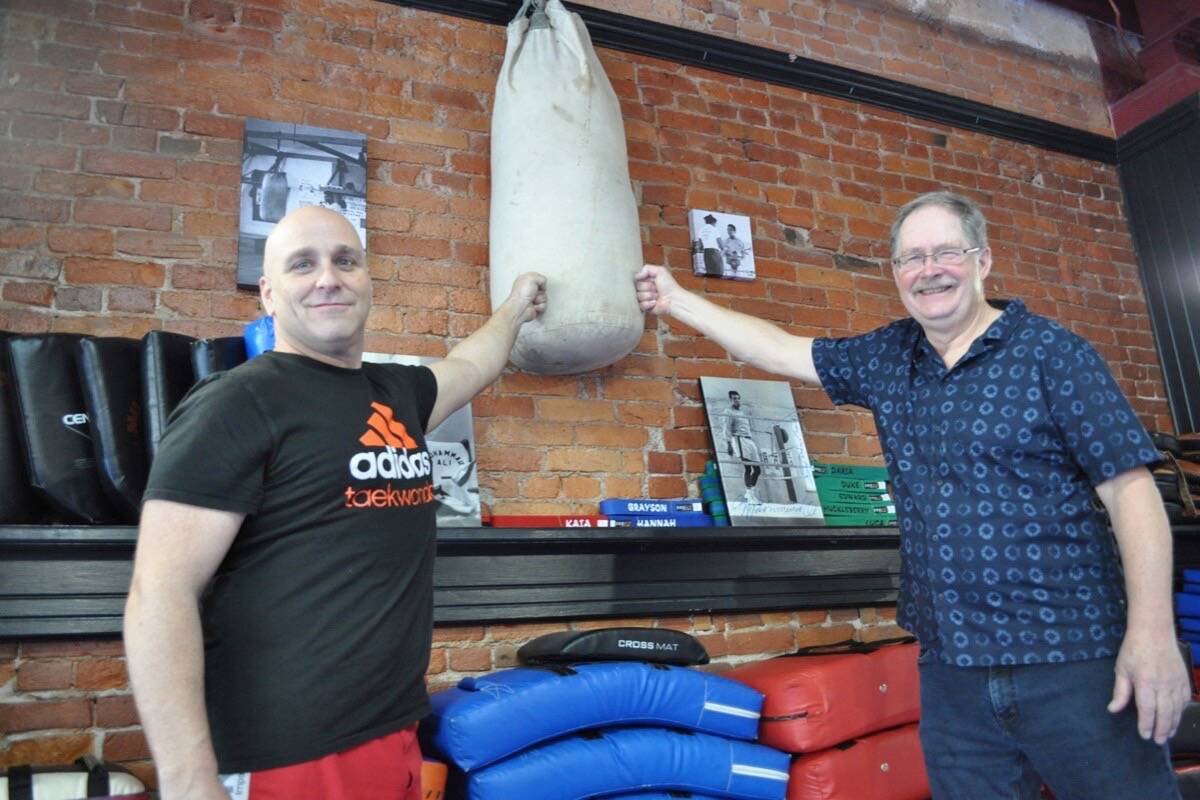 The punching bag is now hung up at Nelsons Yom Chi Martial Arts. It was donated to the dojangs owner Bain Jordahl (left) by John Ius (right), who has granddaughters taking taekwondo classes with Jordahl. Photo: Tyler Harper