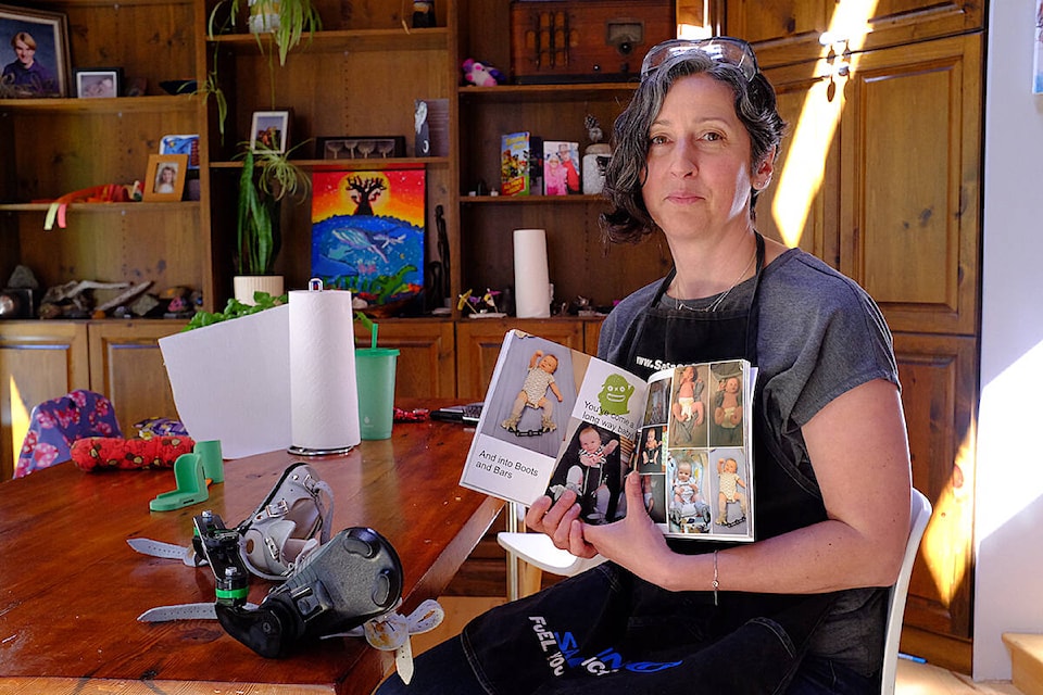 Jeweller and mother Rosie Harris holds a photo album documenting her son’s clubfoot treatment journey. (Olivier Laurin / Comox Valley Record)
