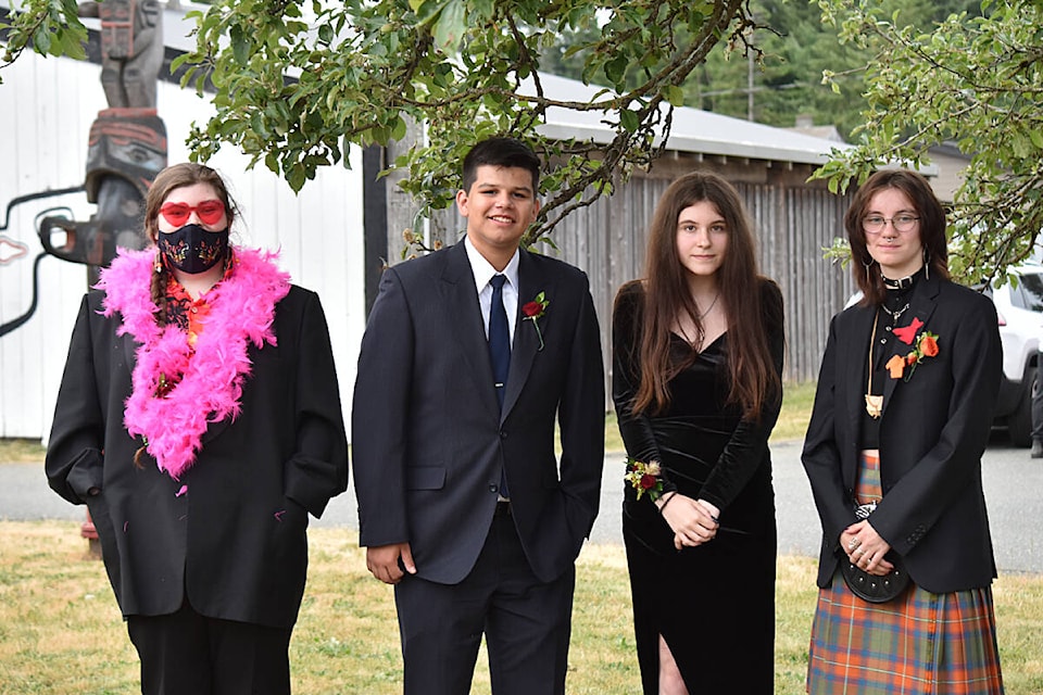 Four of this year’s five graduate students of the Nala’atsi 2023 cohort are posing in front of the K’ómoks First Nation Community Hall on June 15. (Olivier Laurin / Comox Valley Record)