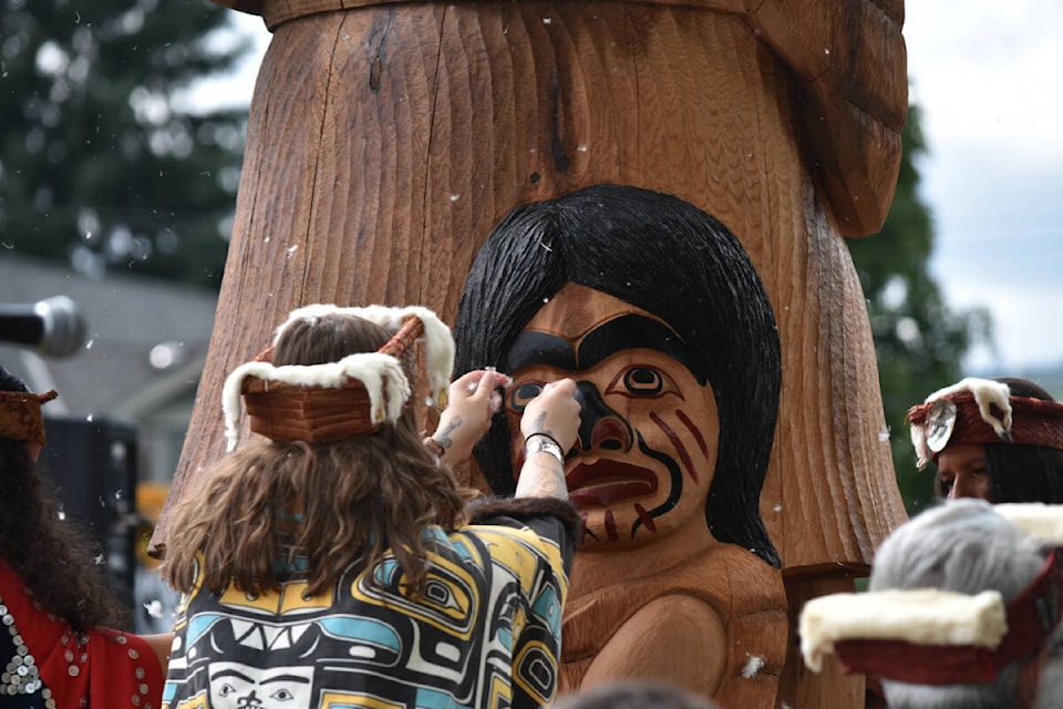 A Kumugwe dancer blessed one of the two totem poles with eagle down feathers. (Olivier Laurin / Comox Valley Record)
