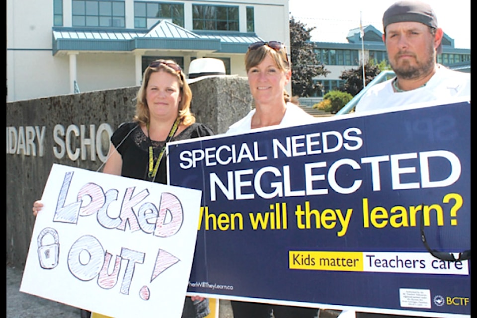 'Teachers Erika Blume, Karen Neuffer, and Brent Pinnell picket in front of Lake Cowichan School on Monday. Teachers will be picketing until such time as an agreement is reached.'