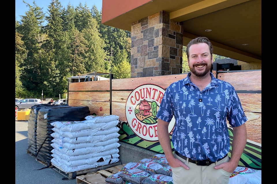 Country Grocer South Island operations manager Craig Cavin stands outside the Cobble Hill location's garden section with a view of nature in the distance. 