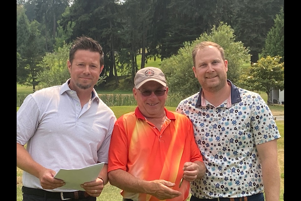 Ted Kennedy, the super seniors men's low net winner, flanked by head pro Jan Best and Eric Butson.