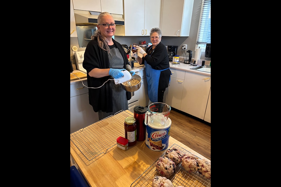Brain on Wheels Rehab Society founder Chris Rafuse, right, and society volunteer Lisa Corbiere work in the kitchen as they prepare for the society's kitchen party on Dec. 13. 