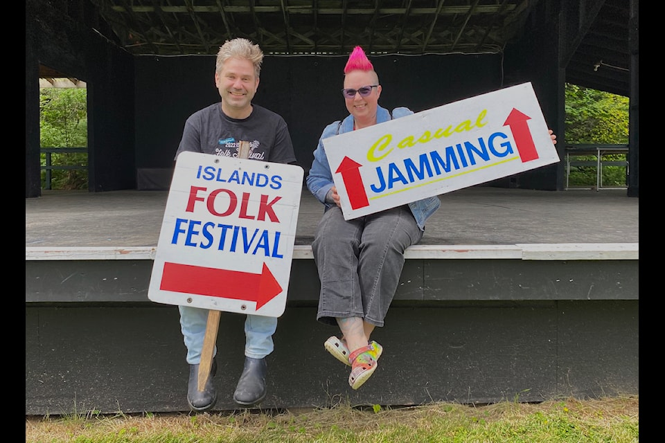 There are signs that good times are near. Cowichan Folk Guild artistic director Jack Connolly (left) and festival chair Asti Williams sit on one five stages at Providence Farm where the 40-year-old Island Folk Festival will run from July 19 to 21.