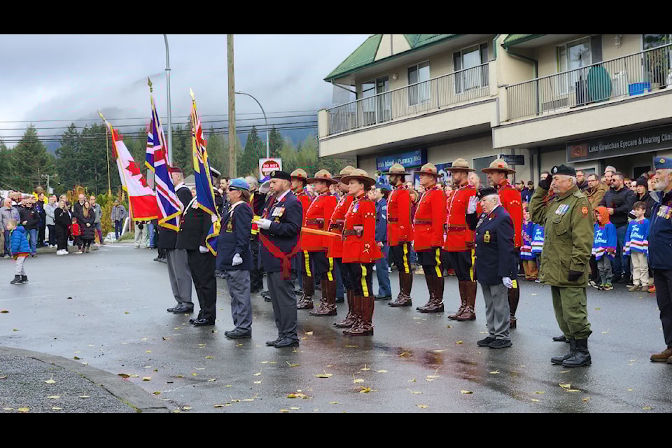 The colour party and the RCMP stand at attention in front of the cenotaph in Lake Cowichan on Remembrance Day, 2024.