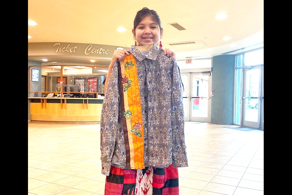 Ten-year-old designer Sally Thorne, who peeks from behind a shirt she made, is off to Toronto as the  youngest participant in the All Nations Fashion Show on Nov. 15. 