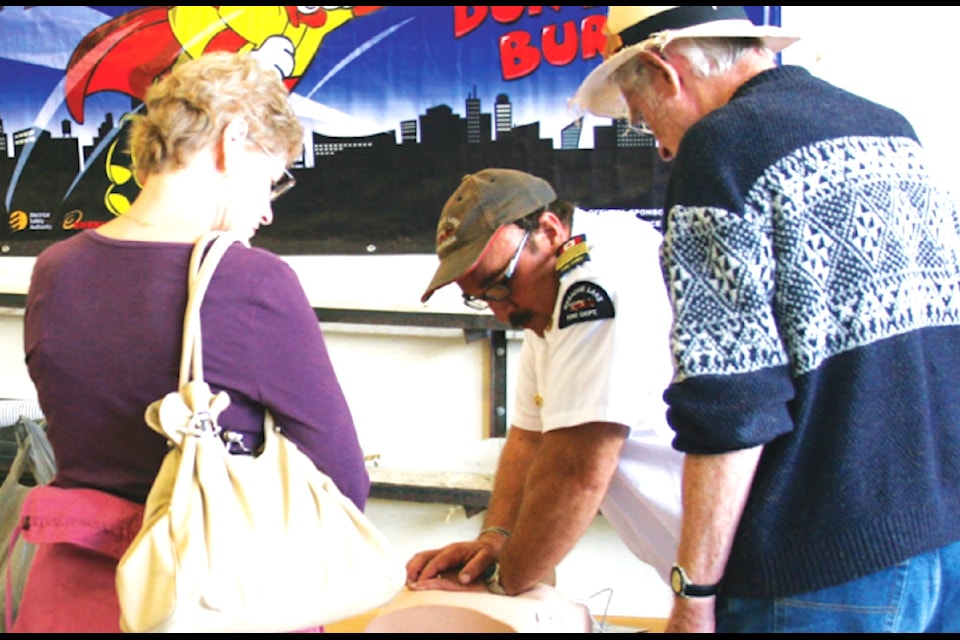 "Fire Chief Gary Eve of Mesachie Lake Volunteer Fire Department demonstrates how to use an AED at the CVRD Recruitment and Retention Drive on Sept. 27 at Honeymoon Bay Fire Hall."