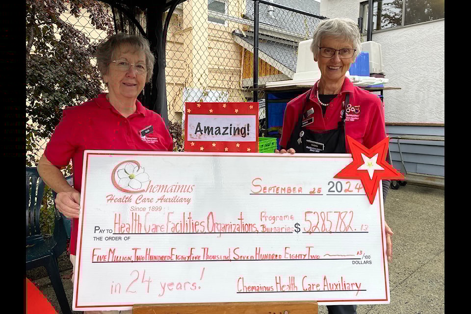 The Chemainus Health Care Auxiliary didn't let the weather rain on their parade of celebrating 125 years of making a difference in the community. CHCA membership coordinator Olga Spensley, left, and committee chair Susan Beaubier stand on either end of this cheque showing the nearly $5.3 million the organizations has raised in donations over the past 25 years. 