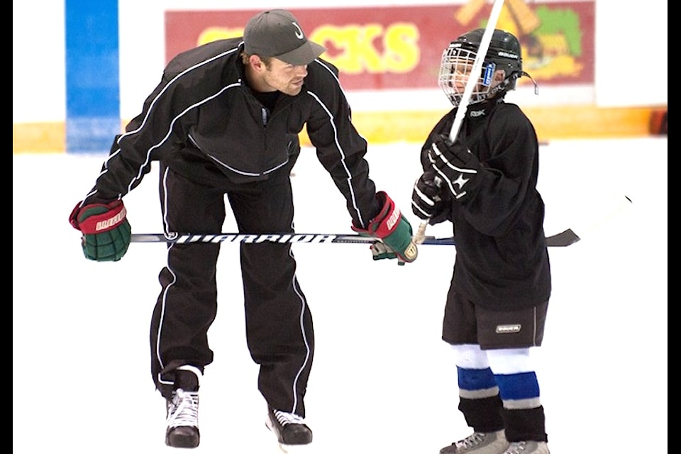 Clayton Stoner shares advice with a young player at a hockey camp. (Black Press file)
